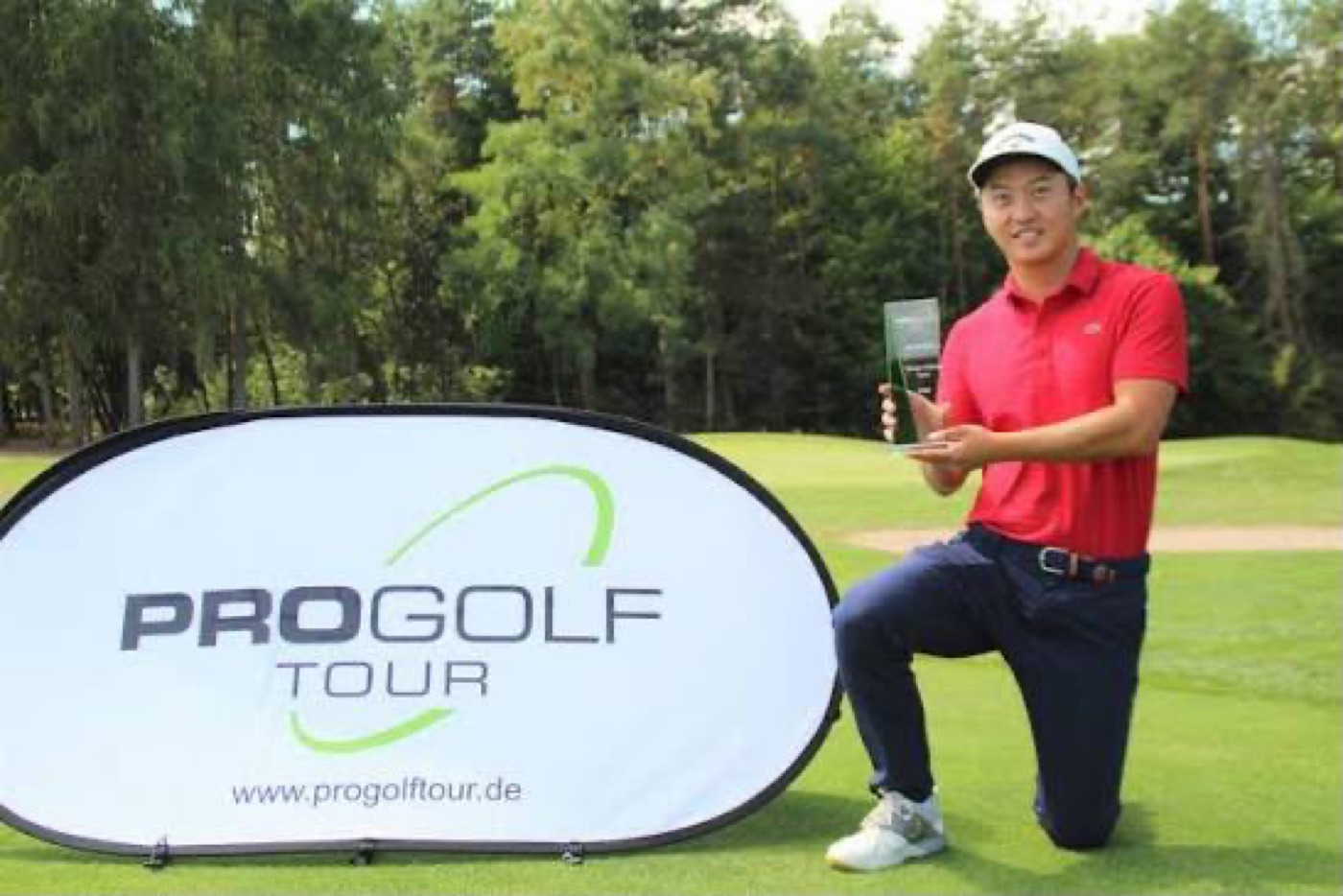 Alexandre Liu, un genou à terre, avec son trophée du Pro Golf Tour